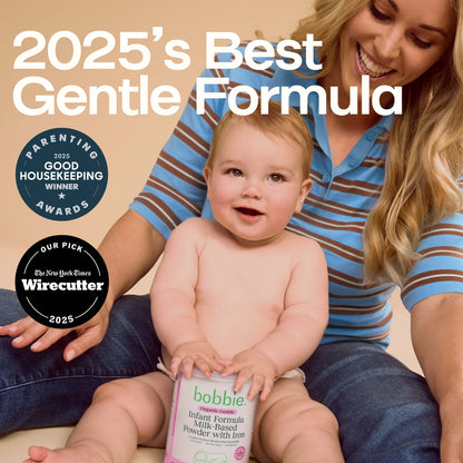 Baby holding a Bobbie Organic Gentle Infant Formula package with a woman sitting next to them, against a beige background.