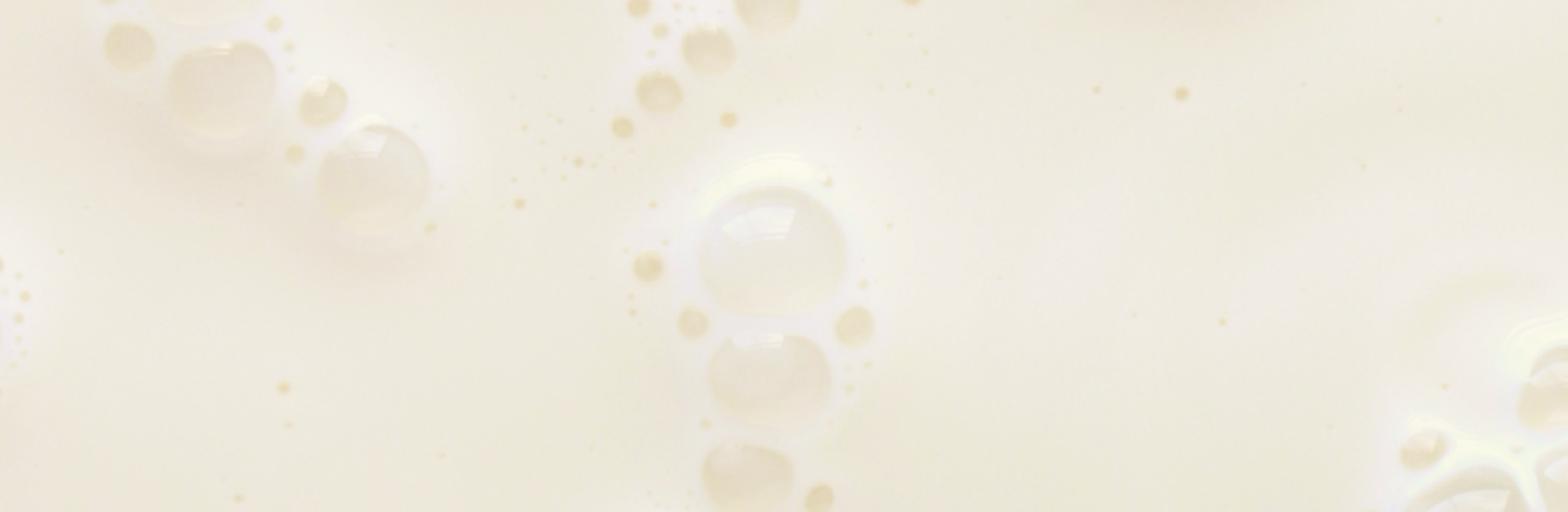 Close-up of a creamy liquid with bubbles, resembling milk or a similar beverage.